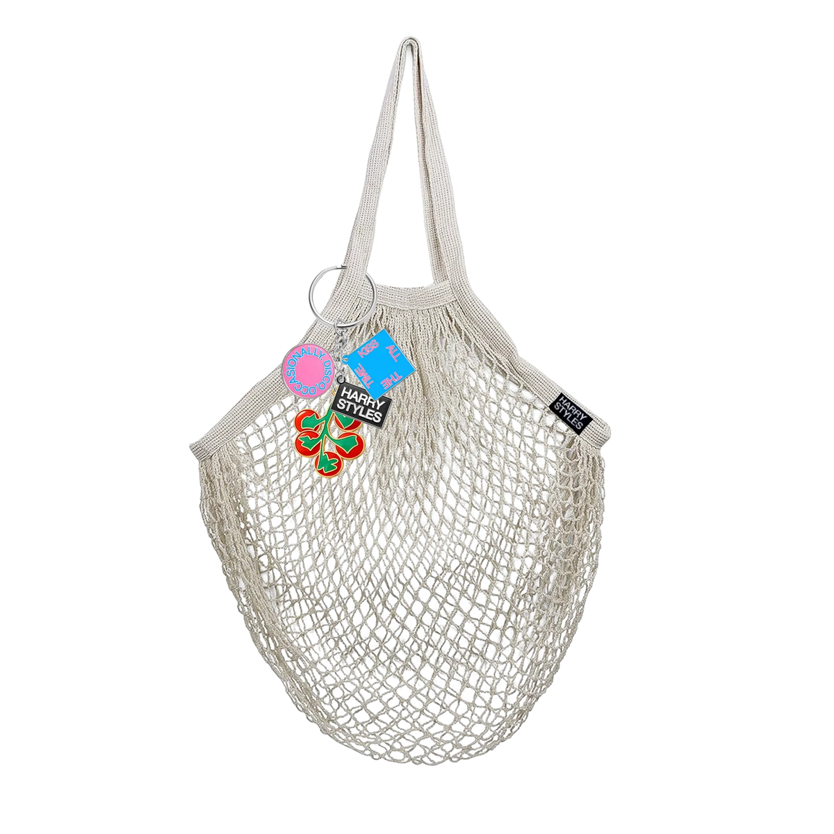 Cream mesh string grocery bag by Harry Styles with a tomato and food charm keychain attached